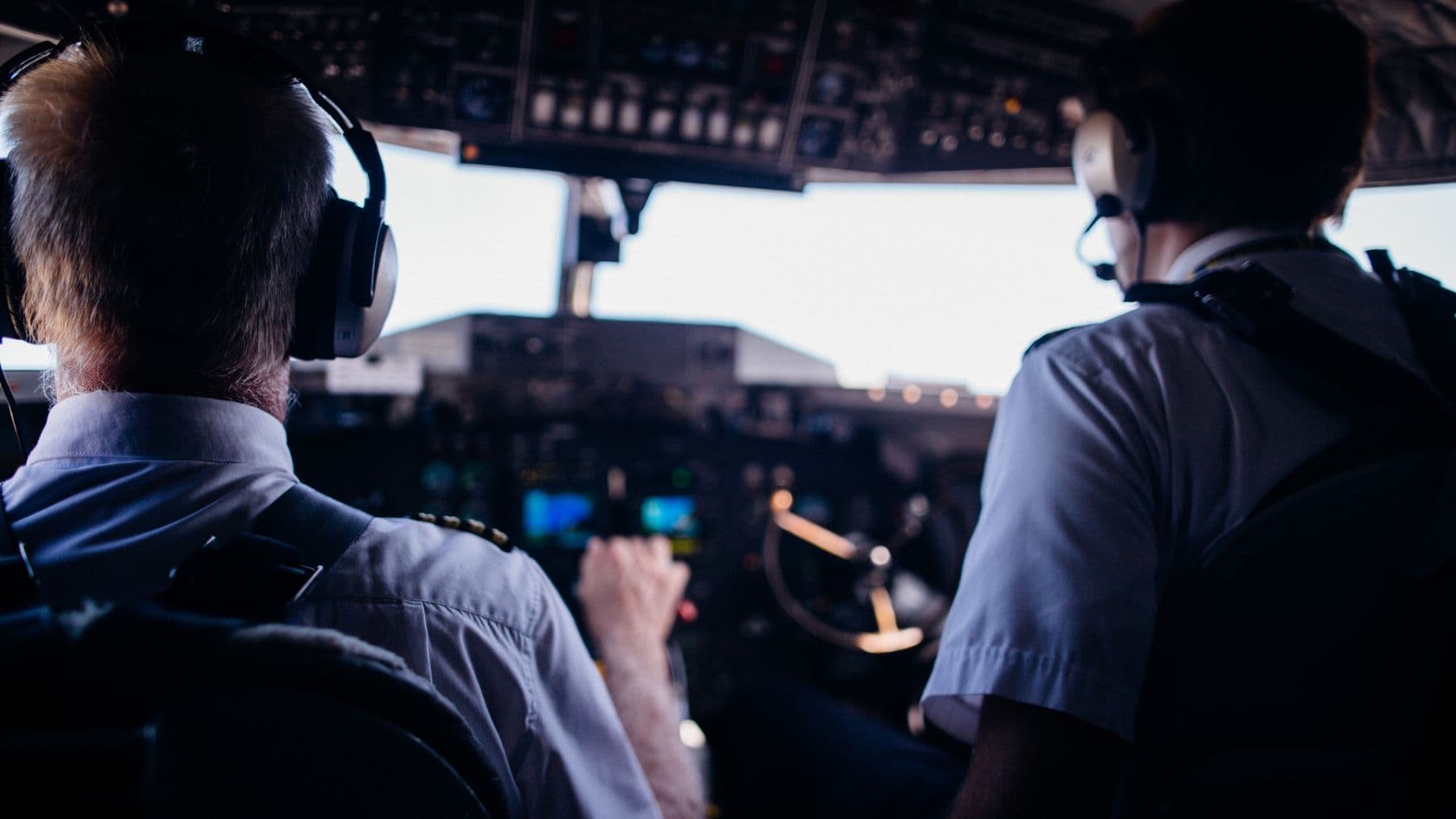 Two pilots coordinating on an aircraft flight deck